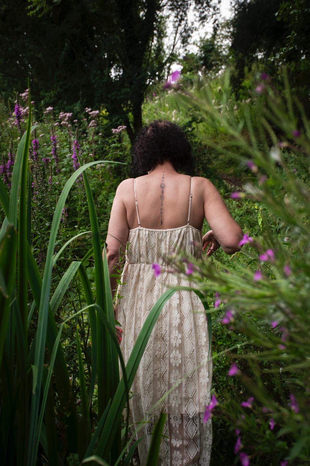 Emma walking through tall wildflowers in Preston