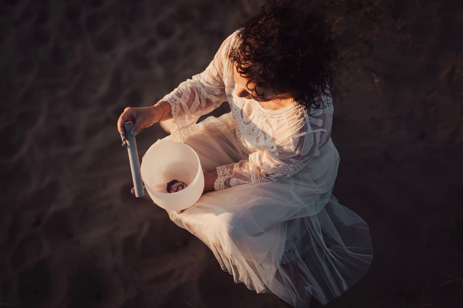 Emma with a crystal singing bowl at golden hour